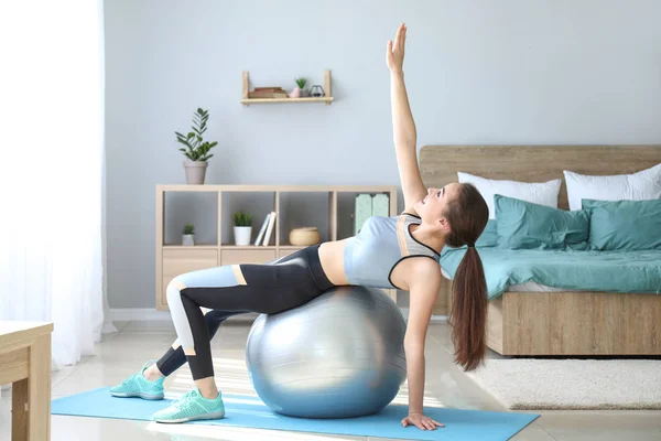 Mujer joven haciendo ejercicio con fitball en casa — Foto de Stock