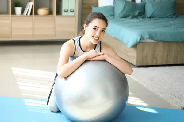 Young woman doing exercise with fitball at home — Stock Photo, Image