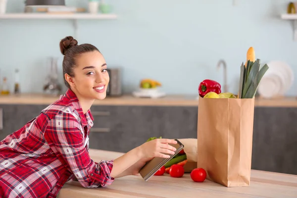 Beautiful woman with fresh products in kitchen at home — Stock Photo, Image