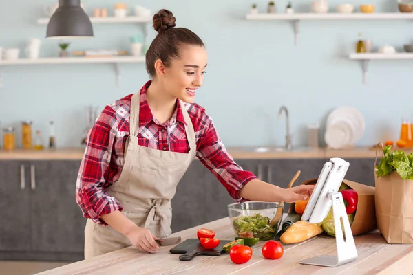 Hermosa mujer preparando sabrosa ensalada de verduras en la cocina en casa —  Fotos de Stock