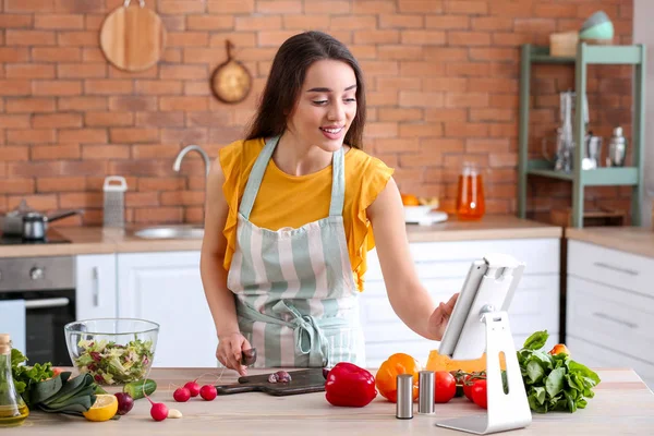 Mulher bonita que prepara a salada vegetal saborosa na cozinha em casa — Fotografia de Stock