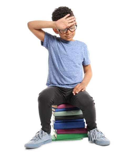 Söt afroamerikansk pojke med böcker på vit bakgrund — Stockfoto
