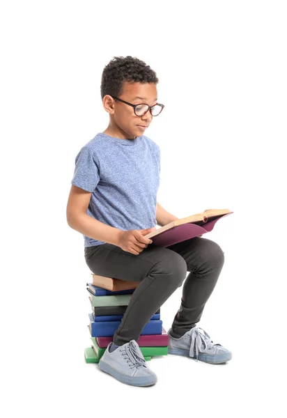 Bonito menino afro-americano lendo livros sobre fundo branco — Fotografia de Stock