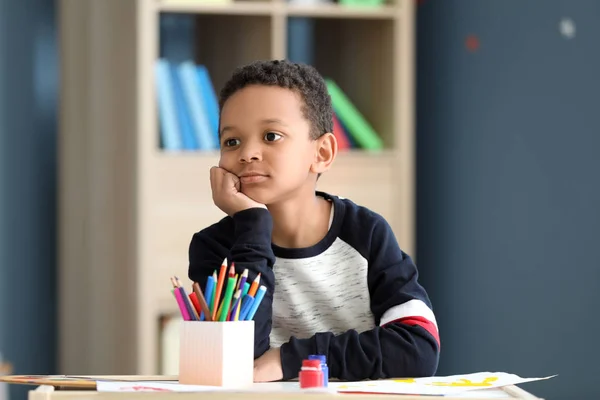 Śliczne African-American chłopiec siedzi przy stole w pokoju — Zdjęcie stockowe