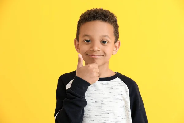 Aranyos afro-amerikai fiú bemutató hüvelykujj-up a színes háttér — Stock Fotó
