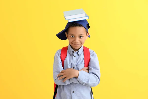 Söt afro-amerikansk skolpojke på färg bakgrund — Stockfoto