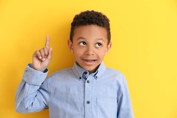 Симпатичный афроамериканец с указательным пальцем на цветном фоне — стоковое фото