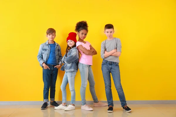 Snygga barn i jeans nära färg väggen — Stockfoto