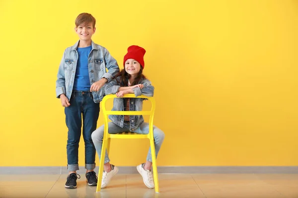 Stylish children in jeans clothes near color wall — Stock Photo, Image