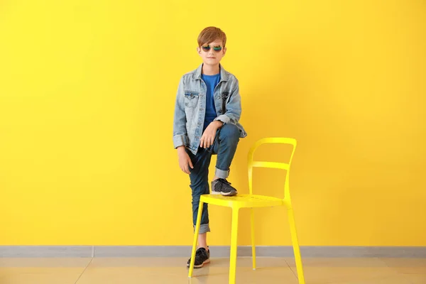 Stijlvolle jongen in jeans kleding in de buurt van kleur muur — Stockfoto