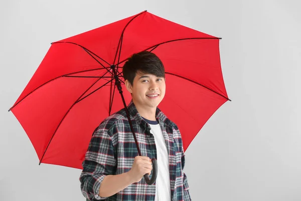 Handsome Asian man with umbrella on white background — Stock Photo, Image