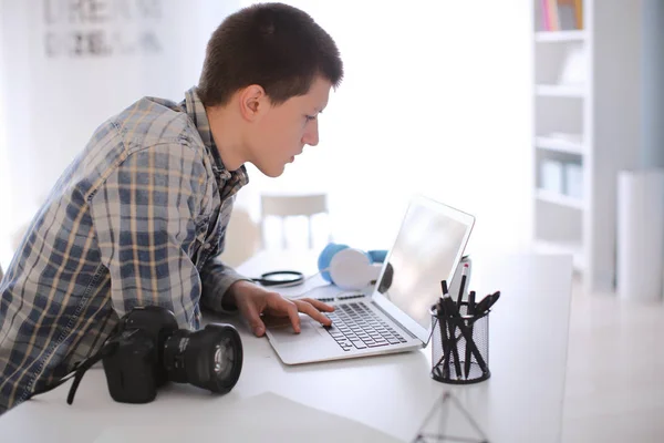 Nastoletni fotograf pracujący na laptopie w domu — Zdjęcie stockowe