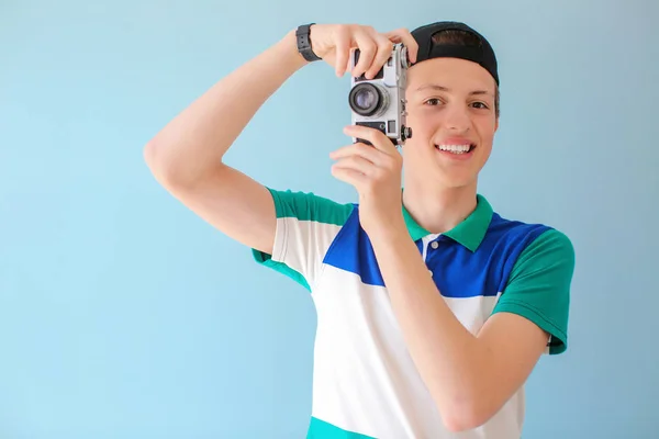 Menino adolescente com câmera de foto no fundo de cor — Fotografia de Stock