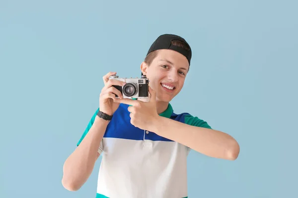 Подросток с фотокамерой на цветном фоне — стоковое фото