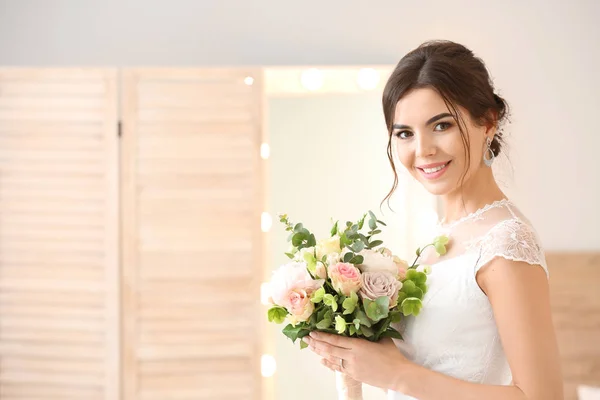 Schöne junge Braut mit Blumenstrauß zu Hause — Stockfoto