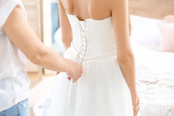 Frau bindet Kleid der schönen jungen Frau zu Hause — Stockfoto