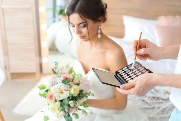 Szakmai sminkes dolgozik fiatal menyasszony otthon — Stock Fotó