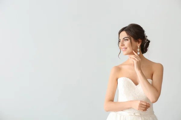 Schöne junge Braut auf hellem Hintergrund — Stockfoto
