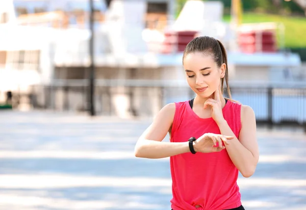 Sporty young woman checking her pulse outdoors — Stock Photo, Image