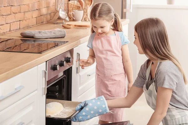 Little girl and her mother baking pastry in kitchen — Stock Photo, Image