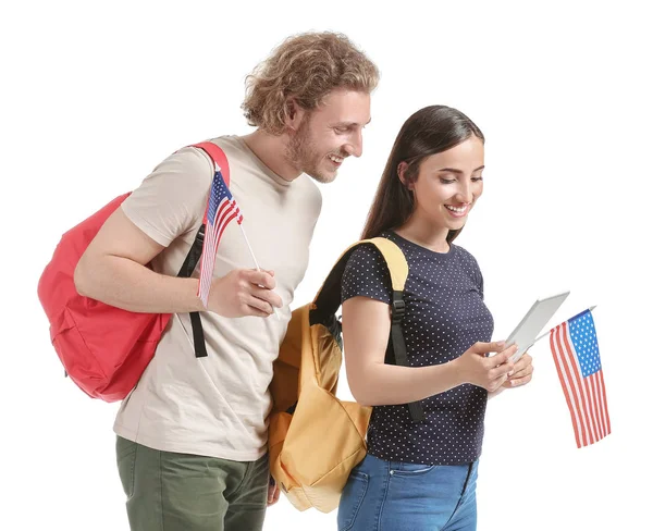 Young students with USA flags and tablet computer on white background — Stock Photo, Image