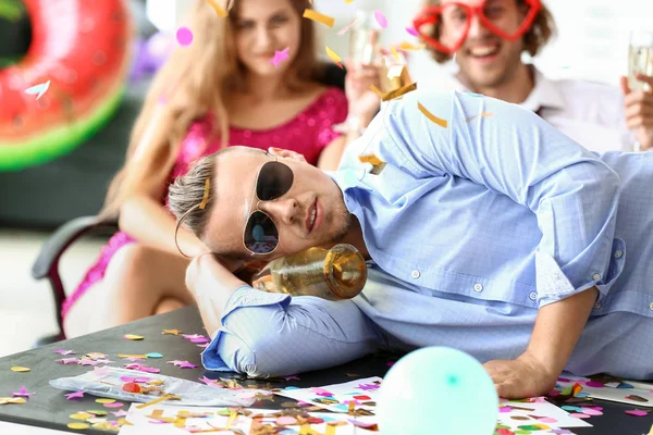 Young man sleeping after party in office