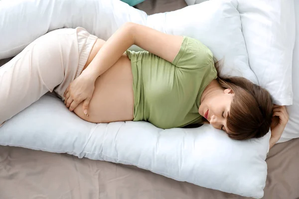 Fiatal terhes nő alszik otthon kismama párna — Stock Fotó