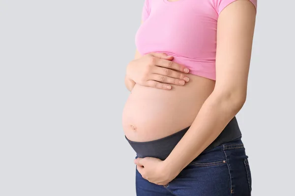 Giovane donna incinta su sfondo chiaro — Foto Stock