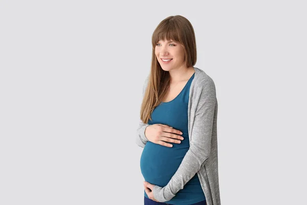 Young pregnant woman on light background — Stock Photo, Image