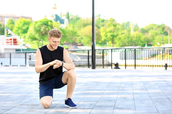 Desportivo jovem verificando seu pulso ao ar livre — Fotografia de Stock