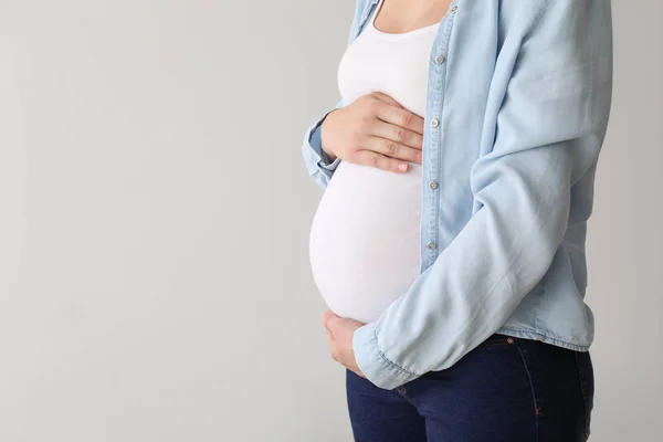 Giovane donna incinta su sfondo chiaro — Foto Stock