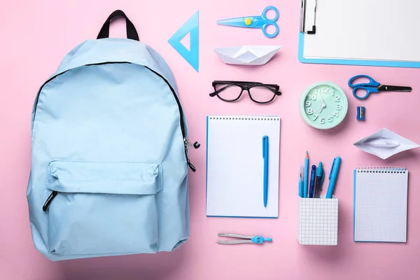 School backpack and stationery on color background — Stock Photo, Image