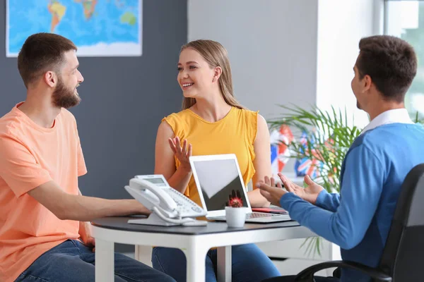 Young couple with travel agent in office — Stock Photo, Image