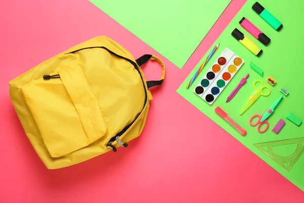 Mochila escolar y papelería sobre fondo de color — Foto de Stock