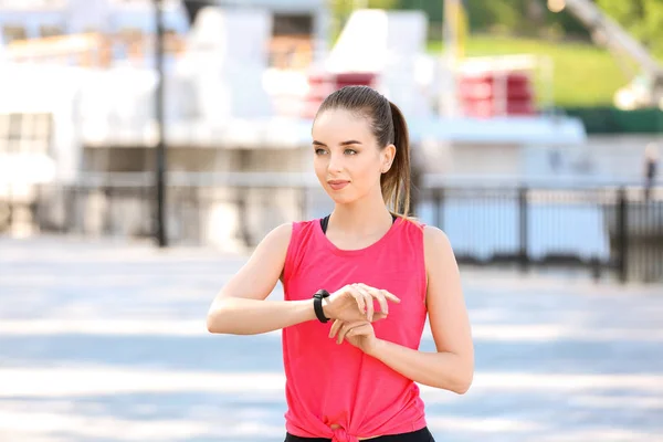 Sporty young woman checking her pulse outdoors — Stock Photo, Image