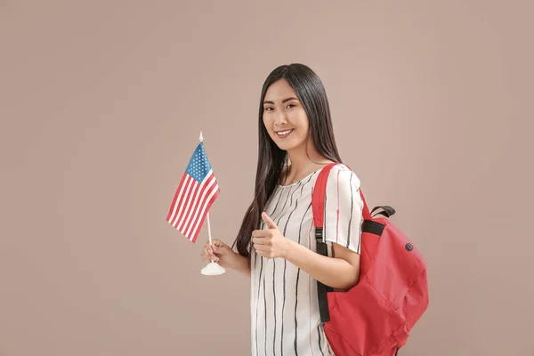 Junge asiatische Studentin mit US-Flagge auf farbigem Hintergrund — Stockfoto