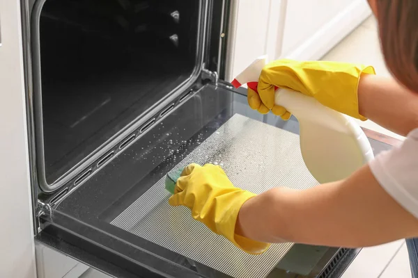 Kobieta czyszczenia pieca w domu — Zdjęcie stockowe