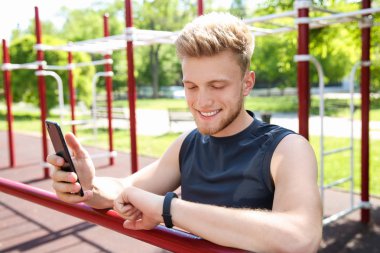 Sportif genç adam nabzını dışarıda kontrol ediyor