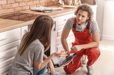 Mutfakta fırın tamir eden bir işçi.