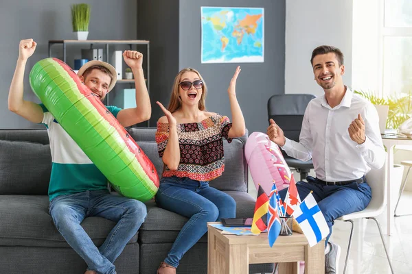 Happy couple with travel agent in office — Stock Photo, Image