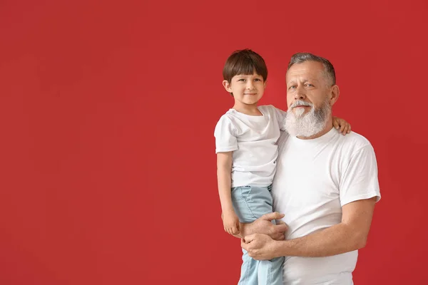 Carino bambino con nonno su sfondo di colore — Foto Stock