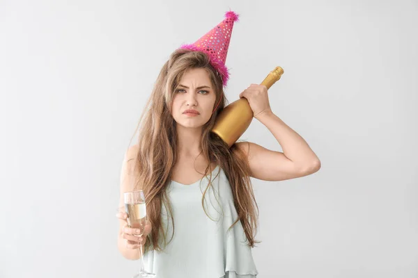 Dronken vrouw met feest hoed en Champagne op lichte achtergrond — Stockfoto