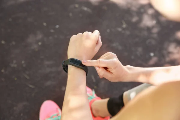 Sporty young woman checking her pulse outdoors, closeup — Stock Photo, Image