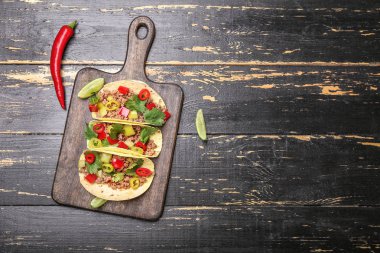 Ahşap masa üzerinde lezzetli taze tacos ile Kurulu