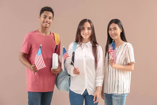 Mladí studenti s USA vlajky na pozadí barev — Stock fotografie