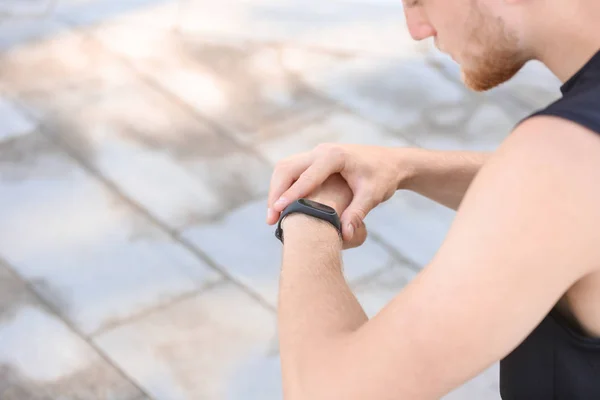 Sporty young man checking his pulse outdoors — Stock Photo, Image