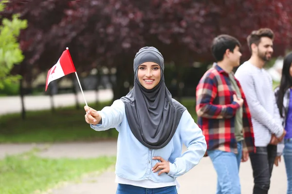 户外悬挂加拿大国旗的女穆斯林学生 — 图库照片