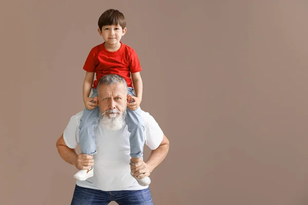 Funny little boy with grandfather on color background — Stock Photo, Image