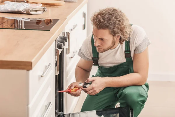 Trabajador reparación de horno en la cocina — Foto de Stock