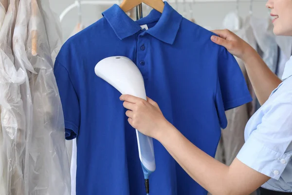 Vrouw stomen kleren in moderne Dry-Cleaner — Stockfoto